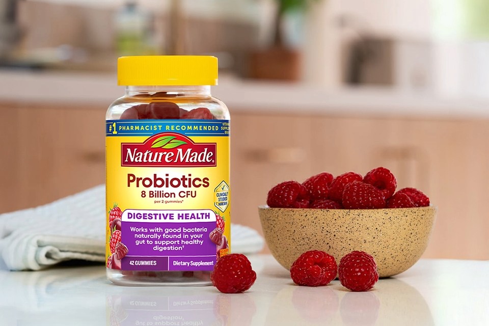 Nature Made Probiotics bottle with raspberries on a kitchen counter