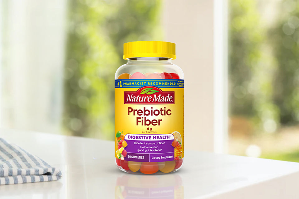 Nature Made Prebiotic Fiber gummies on a white counter next to a hand towel.