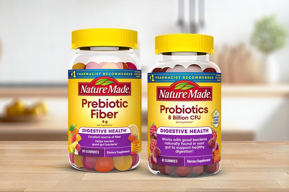 Two bottles of Nature Made prebiotic fiber and probiotics 8 billion CFU on a wooden surface.