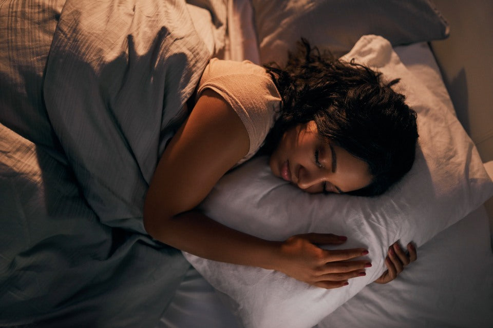 Person sleeping while holding on to a pillow.