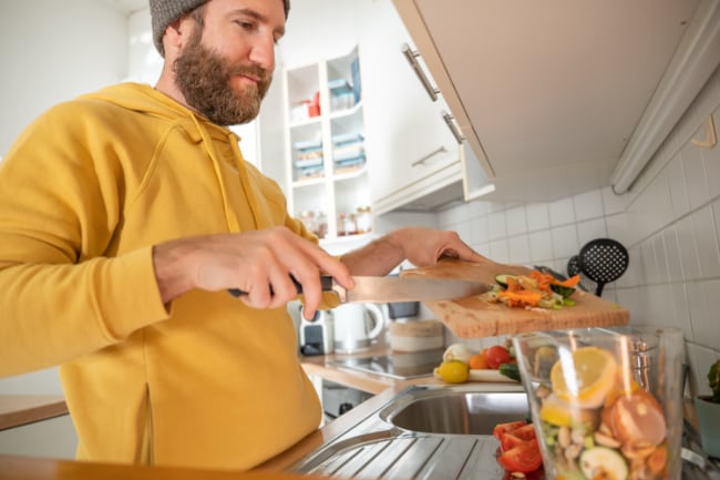 A person preparing a meal with fresh fruits and vegetables