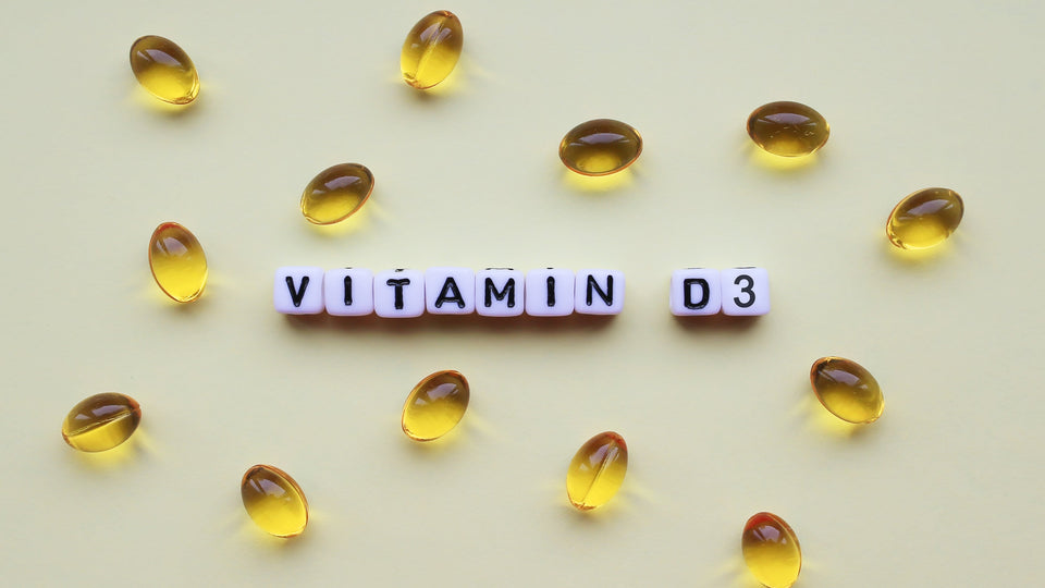 Softgel capsules arranged around “Vitamin D3” text on a solid background.