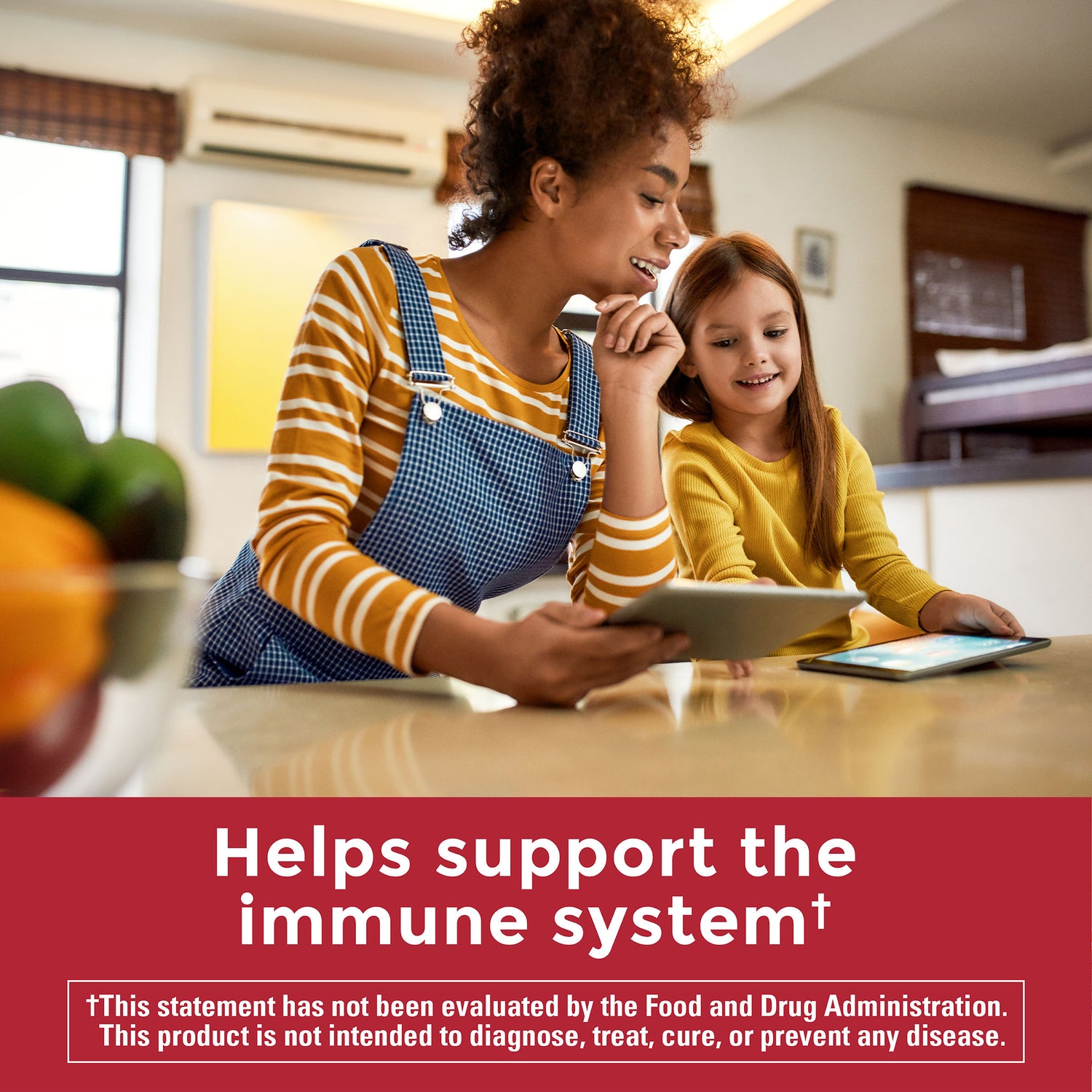 Zero Sugar‡ Vitamin C Gummies 250 Mg Per Serving | Two people sitting at a kitchen table with a tablet and fruit bowl, text reads ‘Helps support the immune system’ on a red banner.