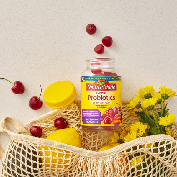 Nature Made Probiotics bottle with fruits and flowers on a light background