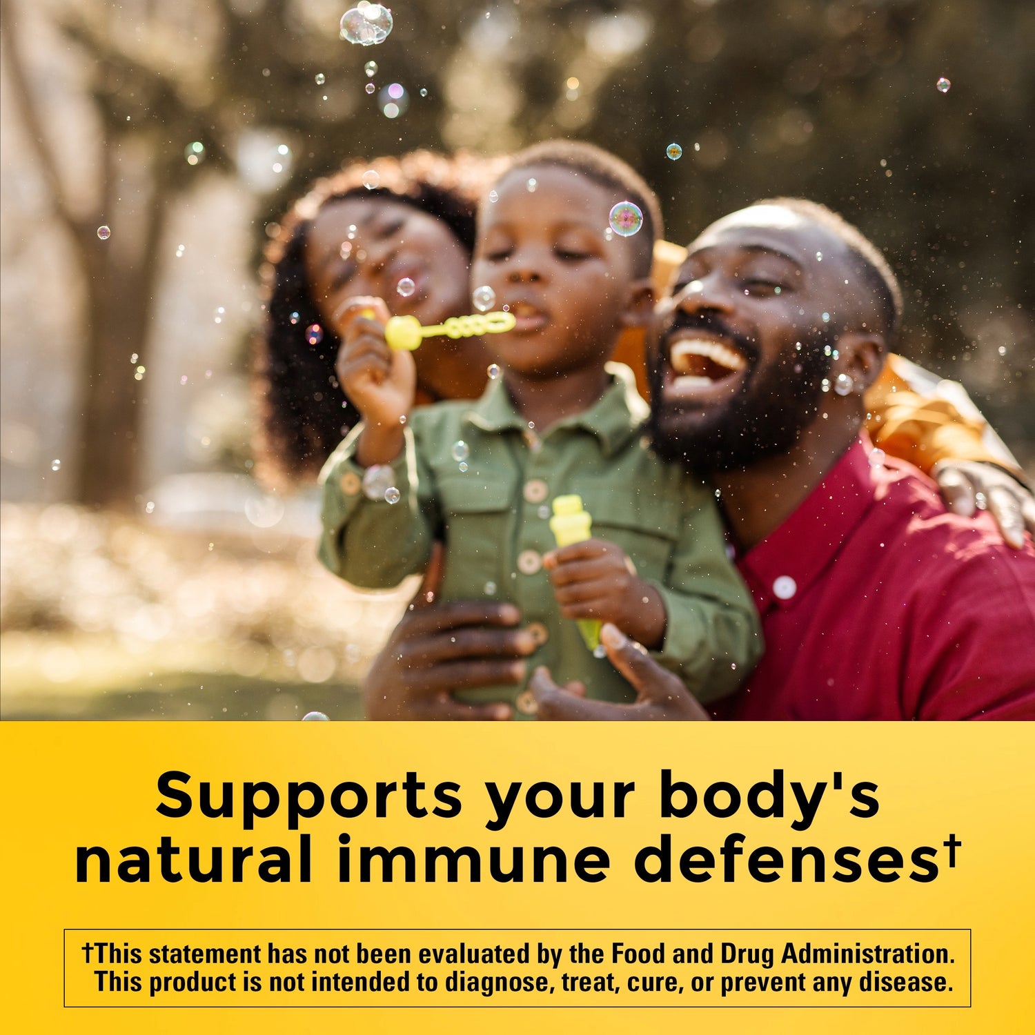 Vitamin E 400 IU (267 mg) d-Alpha Softgels | Family blowing bubbles outdoors with supports your body's natural immune defenses text on a yellow background.