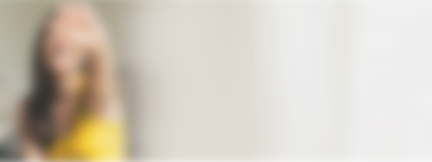 Woman in yellow shirt holding a supplement.